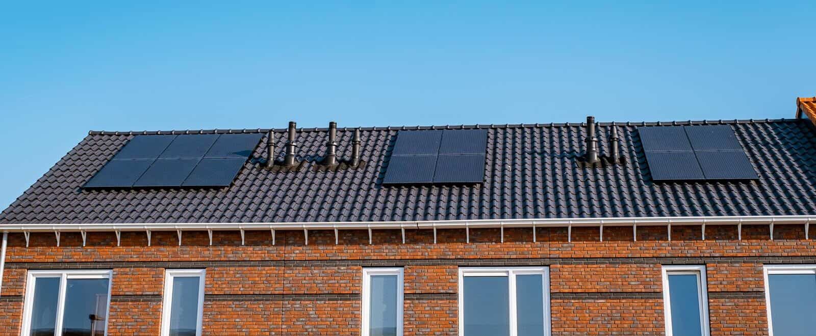 Nieuwbouw huizen met zonnepanelen op het dak tegen een zonnige hemel Close up van zonnepaneel