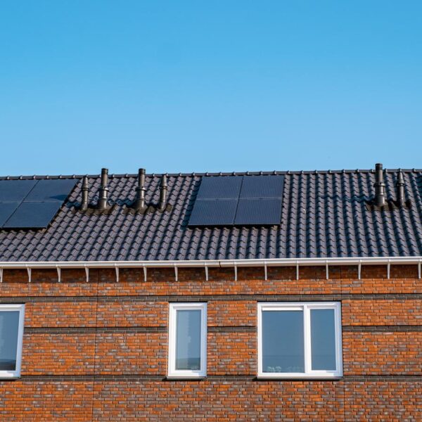Nieuwbouw huizen met zonnepanelen op het dak tegen een zonnige hemel Close up van zonnepaneel