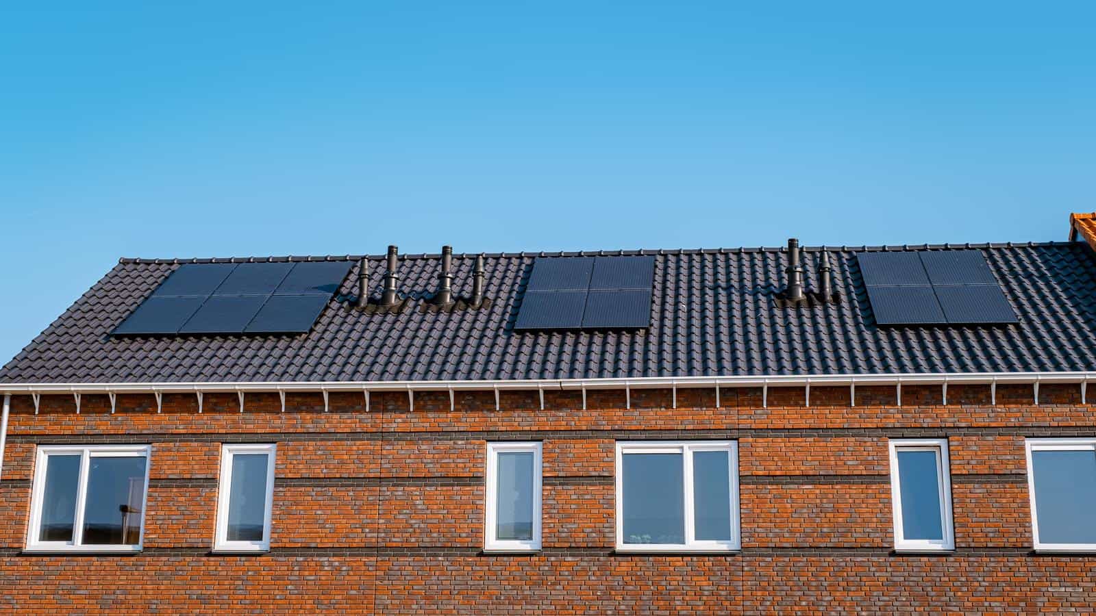 Nieuwbouw huizen met zonnepanelen op het dak tegen een zonnige hemel Close up van zonnepaneel